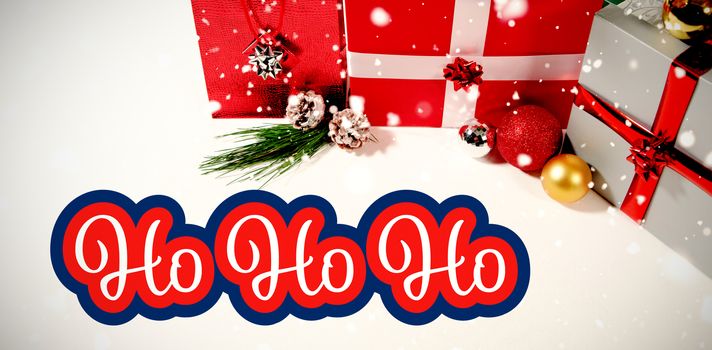 White and red greetings card against christmas gifts against white background