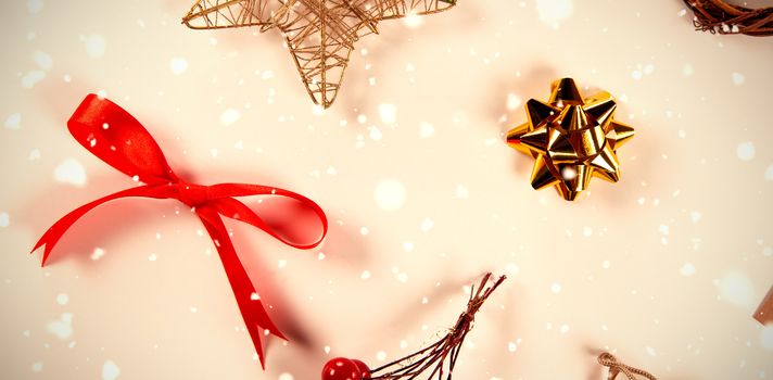 Snow falling against christmas red berries, star and red ribbon