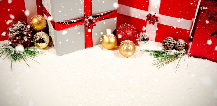 Snow falling against colorful christmas decorations in snow