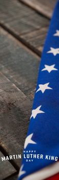 happy Martin Luther King day against folded american flag on wooden table