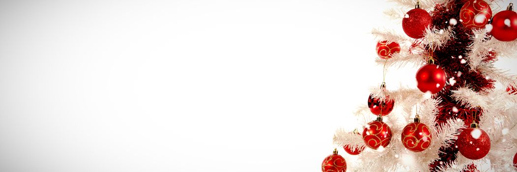 Snow falling against close-up of christmas tree with decoration