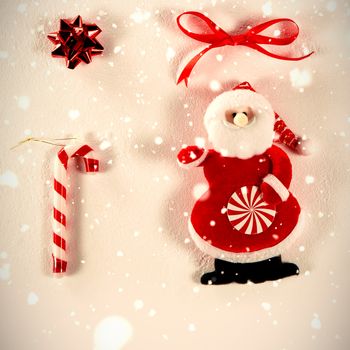 Snow falling against santa claus and other christmas decorations