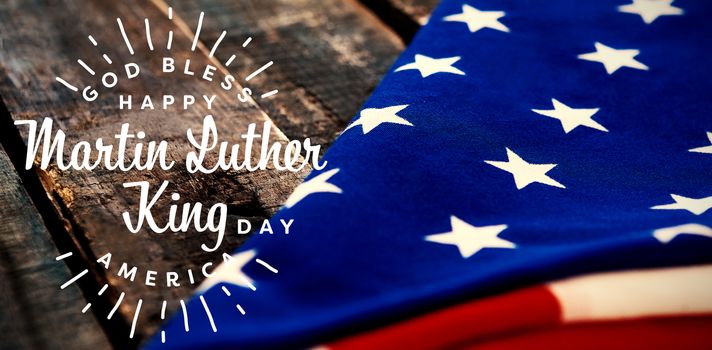 happy Martin Luther King day, god bless america against folded american flag on wooden table