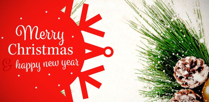 White and red greetings card against christmas decoration covered in snow