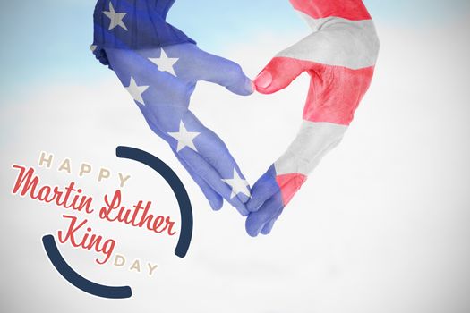 USA flag painted on hands making heart shape against blue sky with clouds 