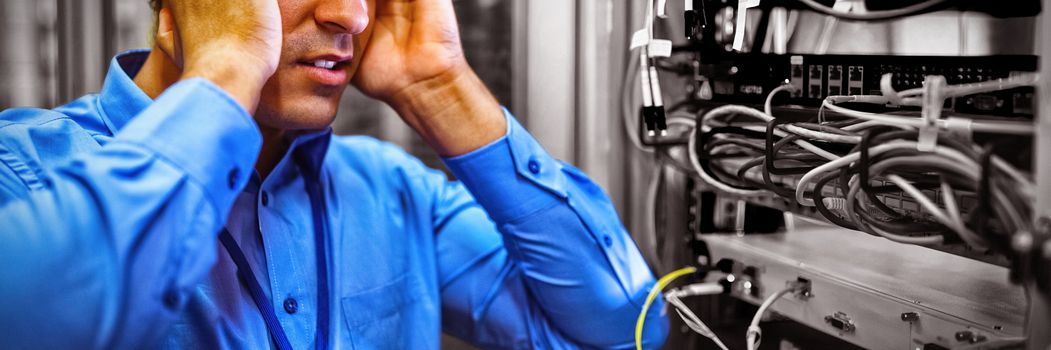 Technician getting stressed over server maintenance in server room 