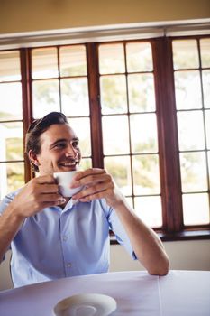 Smiling man having coffee in restaurant
