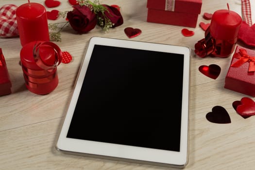 Heart shape decorations, gifts and digital tablet on wooden table