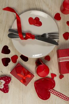 Gift boxes and heart shape decorations with cutlery on wooden table