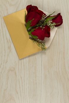Rose bouquet in a envelope on wooden table