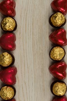 Close-u of chocolates and heart shape decorations arranged on wooden table