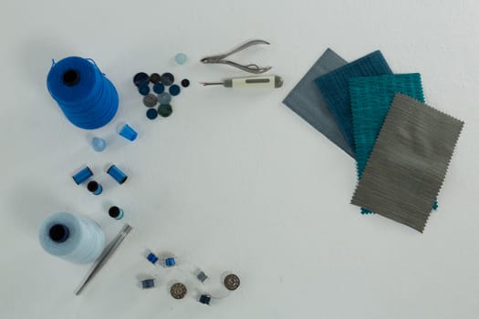Overhead of thread rolls and various tools on white background