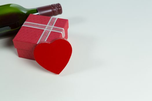 Close-up of wine bottle with valentine gift and decoration on white background
