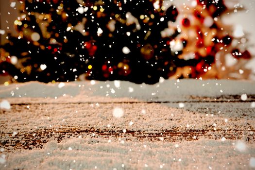 Snow falling against wooden table covered in snow
