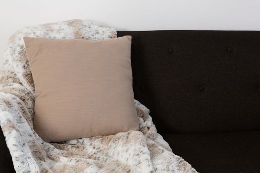 Close-up of cushion and blanket arranged on sofa