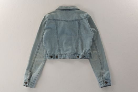 Close-up of denim jacket on white background