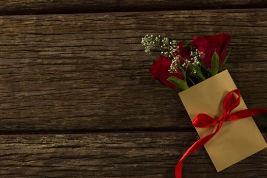 Flower bouquet in a card on wooden plank