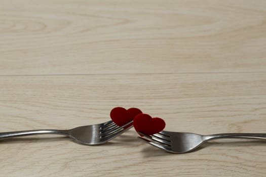 Close-up of heart shape decorations with fork on a wooden table