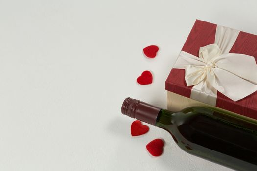 Close-up of wine bottle with valentine gift and decoration on white background