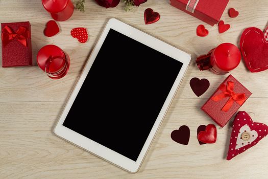 Heart shape decorations, gifts and digital tablet on wooden table