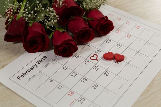 Close-up of rose bouquet with heart shape decorations on February calendar