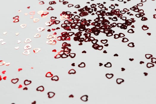 Close-up of heart shape decorations scattered on white background