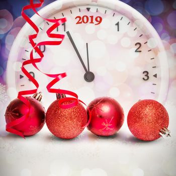 Four red christmas ball decorations against glowing christmas background