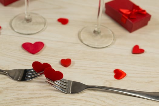 Close-up of heart shape decorations with fork on a wooden table