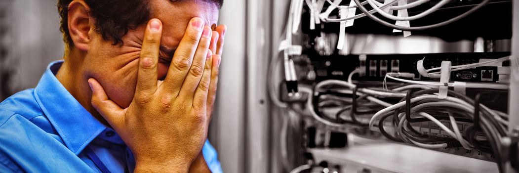 Technician getting stressed over server maintenance in server room 