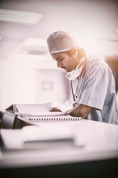 Surgeon reading medical reports at hospital