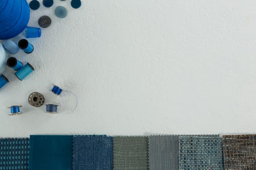 Overhead of thread rolls and various tools on white background