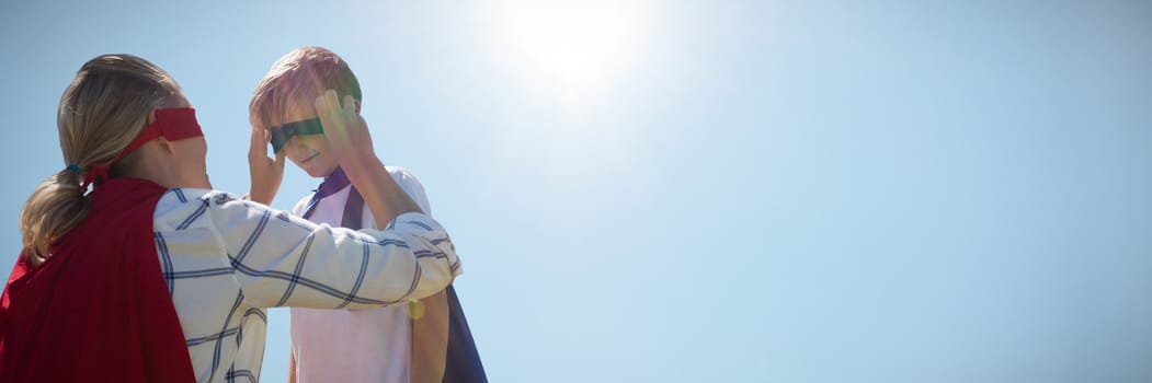 Mother and son pretending to be superhero against low angle view of cloudscape in sky