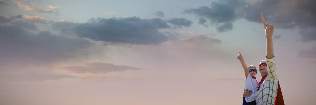 Mother and son pretending to be superhero against low angle view of cloudscape in sky