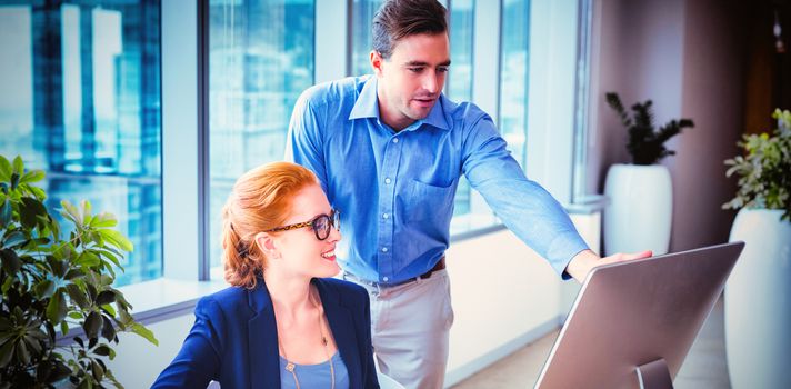 Executives having discussion over personal computer at desk in office