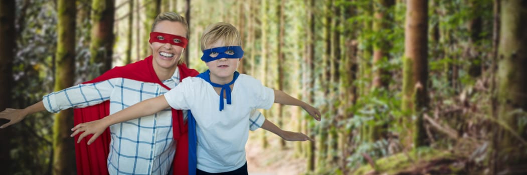 Mother and son pretending to be superhero against empty footpath amidst trees 