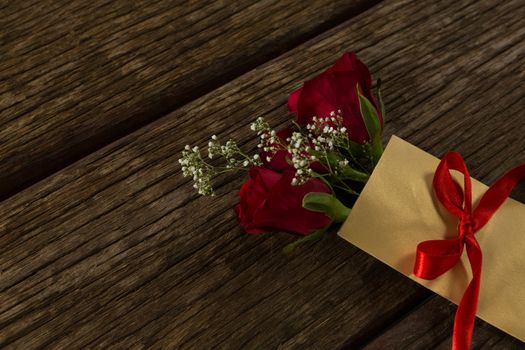 Flower bouquet in a card on wooden plank