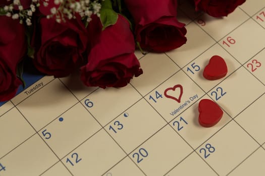 Close-up of rose bouquet with heart shape decorations on calendar