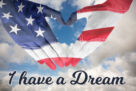 USA flag painted on hands making heart shape against blue sky with white clouds