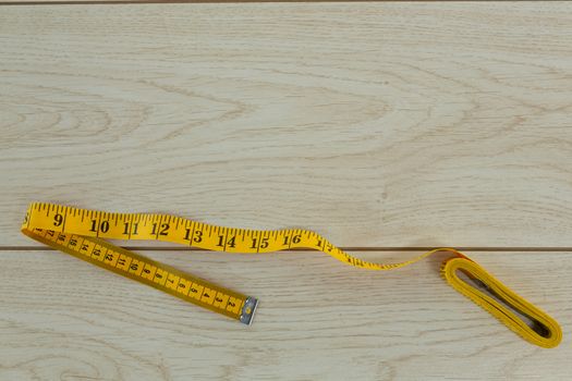 Overhead of measuring tape on a wooden table 