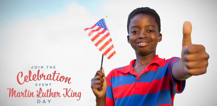 Little boy waving american flag against blue sky with clouds 