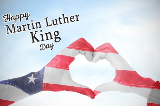 USA flag painted on hands making heart shape against blue sky with clouds 