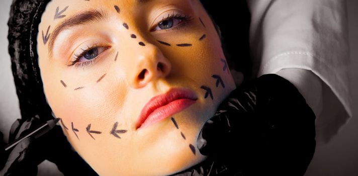 Peaceful young patient with dotted lines on the face in an examination room