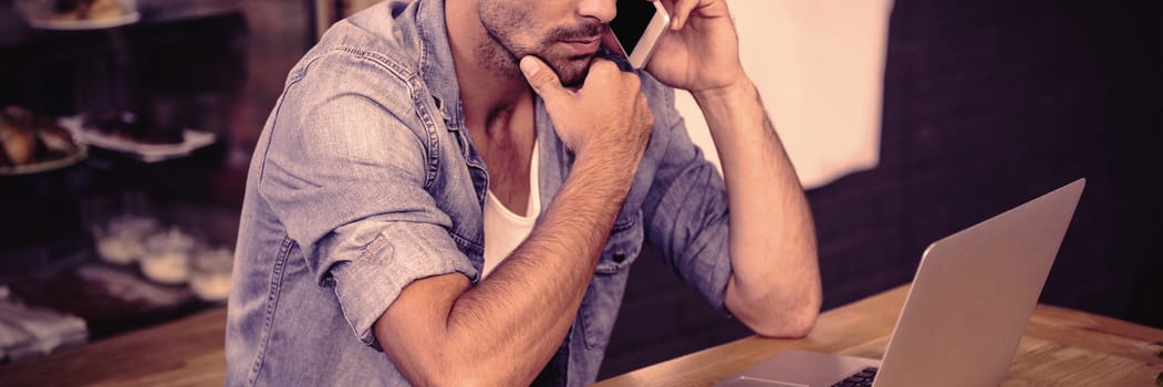 Side view of hipster man working at cafe