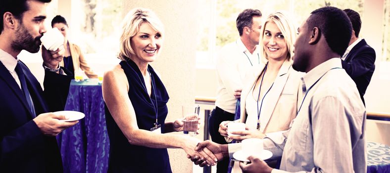 Business executives interacting with each other while having coffee at conference center