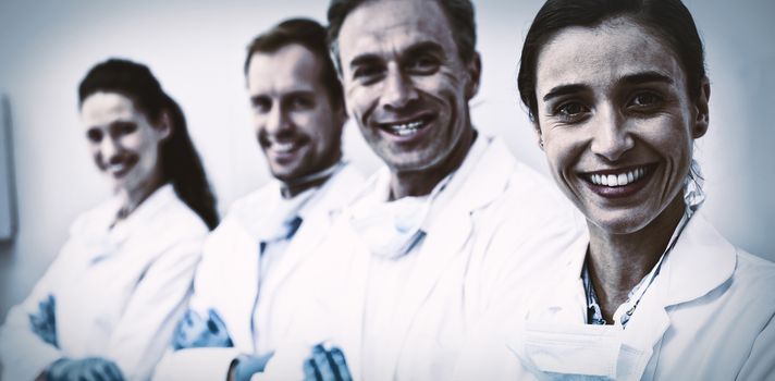 Portrait of smiling dentists standing with arms crossed in dental clinic