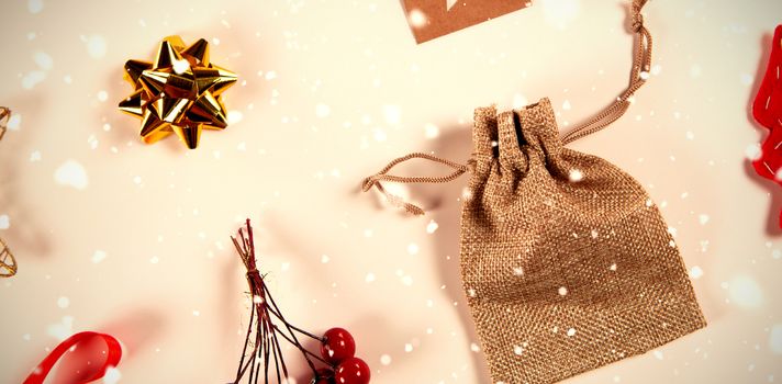 Snow falling against close-up on rustic christmas ornaments