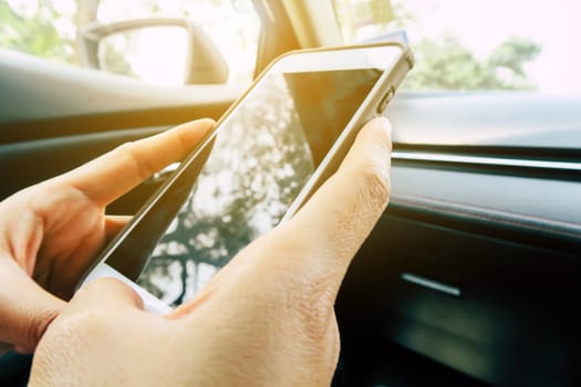 image of people using a smartphone  inside of a car.