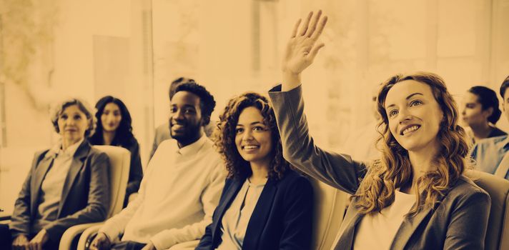 Businesswoman with colleagues raising hand during meeting in office