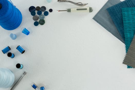 Overhead of thread rolls and various tools on white background