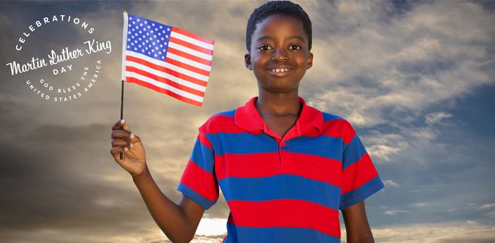 Little boy waving american flag against cloudy sky landscape